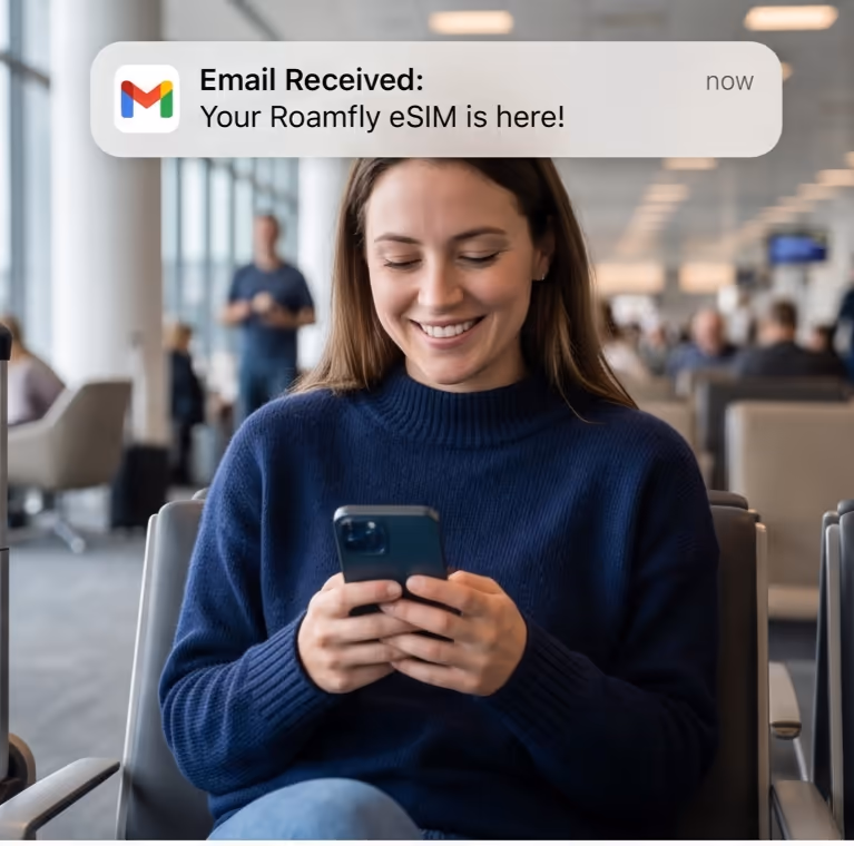 Traveller at the airport receiving an eSIM email confirmation